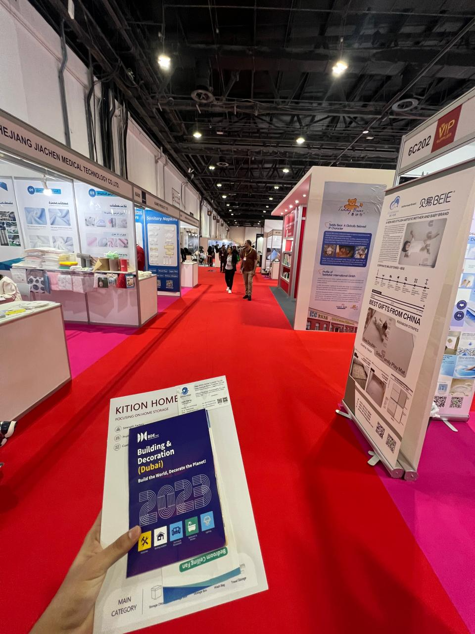 Trade show exhibition aisle with supplier booths and product displays